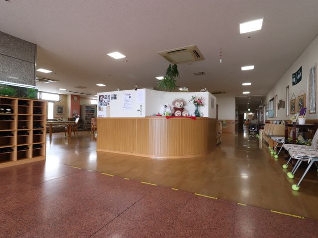 応接エリアの広々としたロビー エントランス ゆったりとした造りの受付周辺は、温かな雰囲気を感じさせます。来訪者との対話も心地よく行える空間です。
