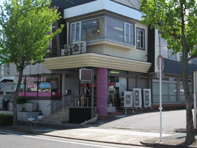 入り口がある建物 外観 車でのアクセスが便利な立地です。周囲には豊かな緑が広がり、自然を感じられる施設です。
