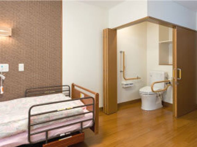 ベッドとトイレの居室 居室 広々とした居室です。車椅子でも快適に利用できるバリアフリートイレがあります。