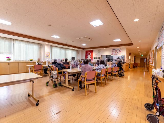食堂の様子 共有スペース 明るく広々とした食堂では、利用者がくつろいで食事をとっています。多様なニーズに配慮した椅子やテーブルが配置されており、快適な空間が保たれています。