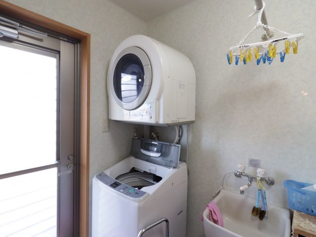 洗濯機と洗面所の空間 ランドリールーム 清潔感のある洗面台と洗濯機が備わった実用的な空間です。利用者の快適な生活をサポートする設備が整っています。