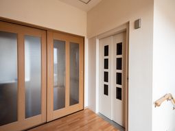 木目調の扉と白いエレベーター