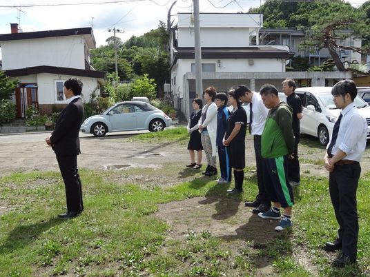 屋外で並ぶ職員たち  