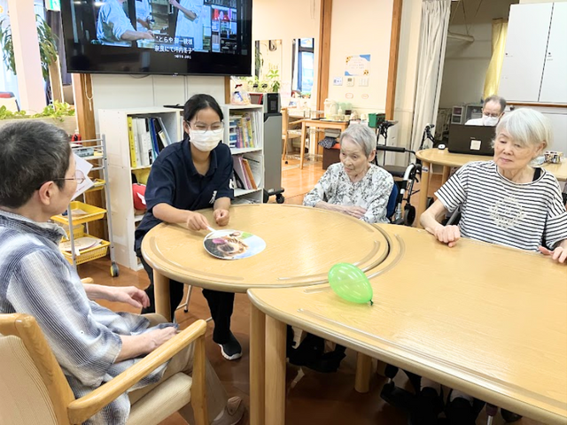 楽しそうな様子の室内 多目的室 広々とした空間で、スタッフと共にテーブルを囲んで楽しんでいます。和やかな雰囲気が魅力的です。
