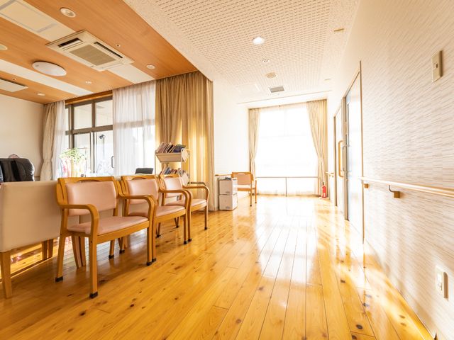 暖かみのある待合室 共有スペース ゆったりとした椅子が並び、明るい日差しで満たされた落ち着きのある空間です。