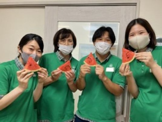 スタッフ4人が並ぶ室内  