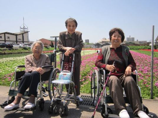 笑顔の利用者様三名中庭で