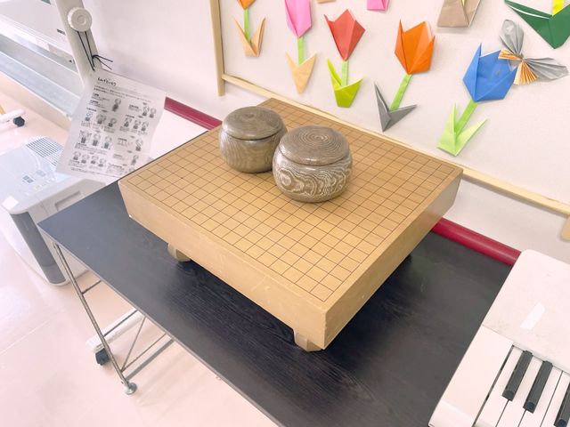 囲碁盤と折り紙の室内 多目的室 囲碁盤と折り紙が並ぶ、心落ち着く多目的スペース。ゲームやアクティビティに最適です。