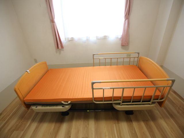 安全なベッドの居室 ベッド 明るい窓辺のシンプルなベッドです。安全のための柵が付いています。