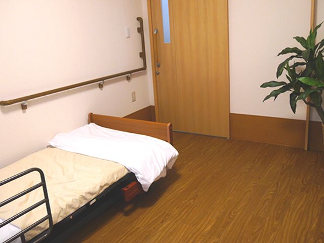 落ち着いた居室 居室 温かみのある木材を使用した床が心地よさを感じさせます。植物が置かれた和やかな空間です。