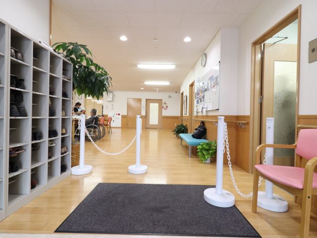 清潔なエントランスホール 玄関 広々としたエントランスホールは、清掃が行き届き癒しの空間です。気配りが感じられるスタッフと利用者さまの穏やかな会話が交わされています。