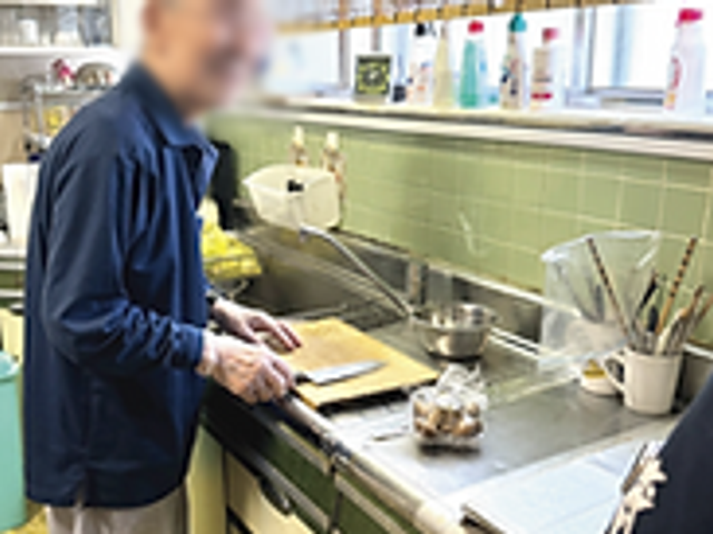 調理中の人がいるキッチン キッチン 広々としたスペースで、日中も自然光が差し込み、快適に調理ができる環境です。