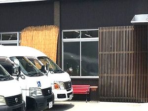 送迎車が並ぶ玄関外観  