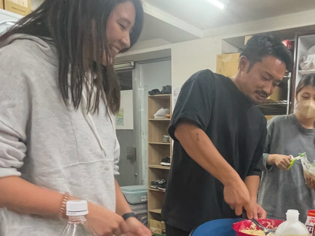 料理を楽しむ人々 キッチン リラックスした雰囲気のキッチンで、スタッフが協力して料理を楽しんでいます。テーブルが広々しています。