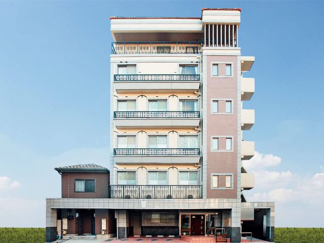 高層建物の外観 外観 高層の建物で、周囲には青空が広がっています。一階には広いエントランスがあります。