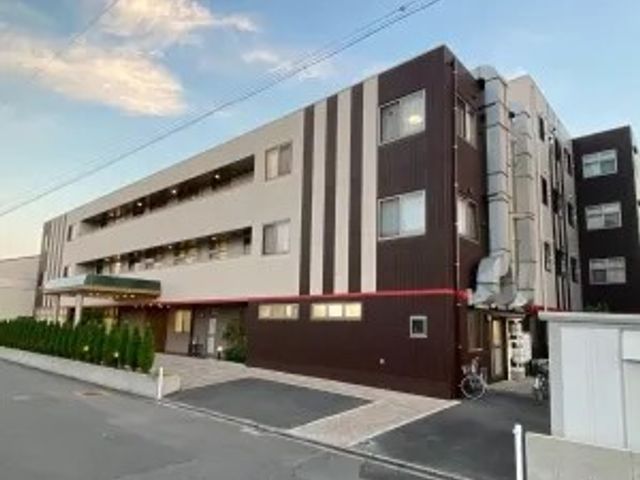 建物外観 外観   落ち着いた色合いの建物で、通路側に屋根付きの出入口が見えます。就業を考える方は、施設全体の規模感をつかみやすいです。