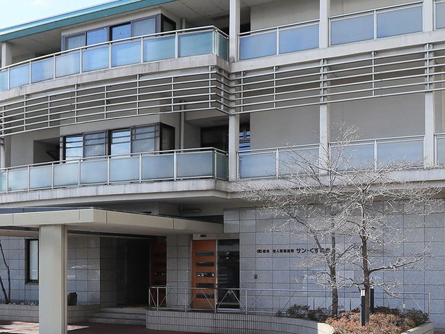 白い外壁の建物外観 外観 清潔感あふれる外観は、高齢者にとって安心感を与えます。広々としたエントランスが魅力です。