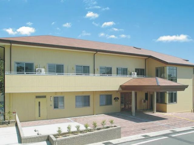 施設の外観 外観   明るいベージュの外壁と、ゆったりしたひさしが印象的な建物です。駐車スペースも見え、来訪しやすい雰囲気です。