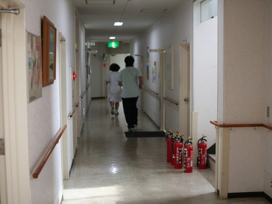 廊下を歩く職員と利用者の後ろ姿  