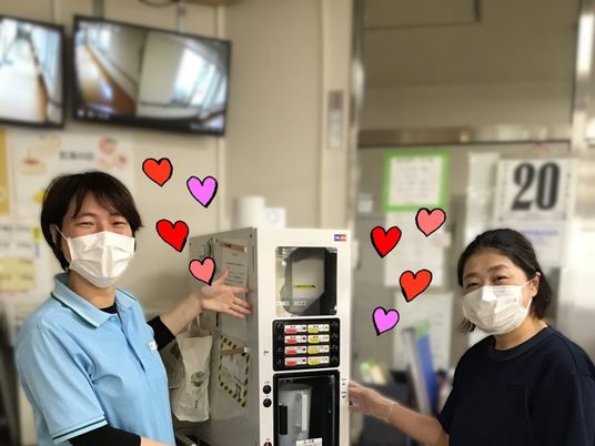 スタッフ2人と自販機の休憩室  