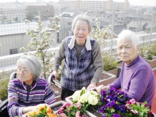 屋外で花に囲まれた人々