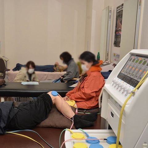 リハビリの様子 機能訓練室 広々とした空間で、リハビリが行われています。利用者とスタッフが一緒に取り組んでいます。