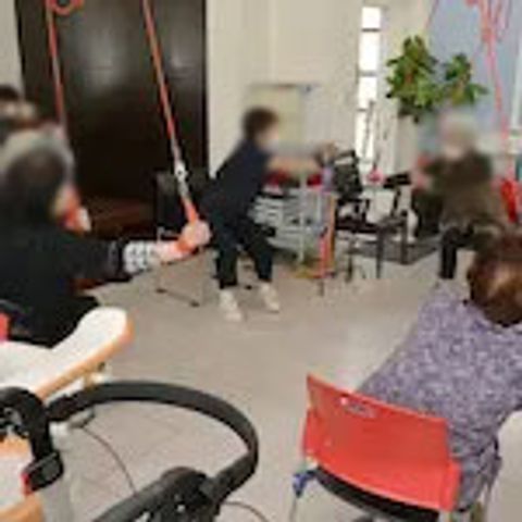 体操する人々の室内 機能訓練室 自然光の中で体操を行う施設です。和やかな雰囲気で運動を楽しめます。