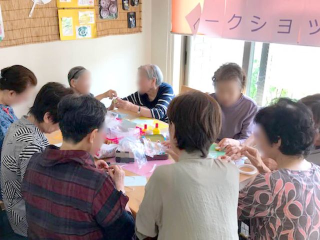 手工芸を楽しむ人々 多目的室 共有スペースでの手工芸の様子です。笑顔で何かを作っているので、創造的な一時を過ごす場となっています。