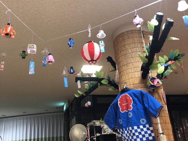 飾り付けのダイニングルーム ダイニングルーム 天井から吊るされた飾りが華やかな空間で、お祭りを連想させるアイテムが展示されています。車椅子が容易に使用できるよう設計されているようです。