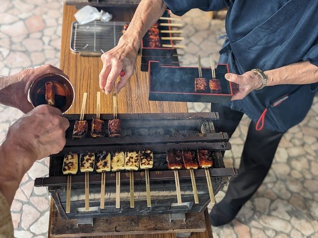 屋外での調理風景 料理 具材が並び、皆で楽しく焼き物を楽しむ場面です。和やかな雰囲気が伝わってきます。