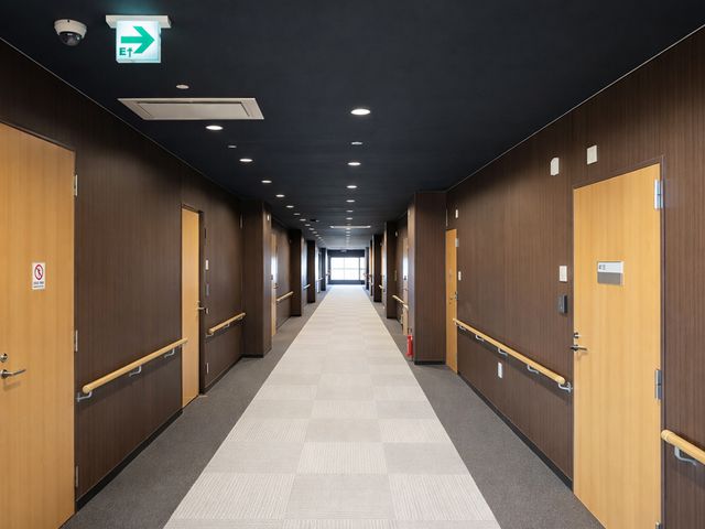 広々とした廊下 廊下 明るい空間の長い通路で、両側に手すりが設置されています。快適に移動できます。