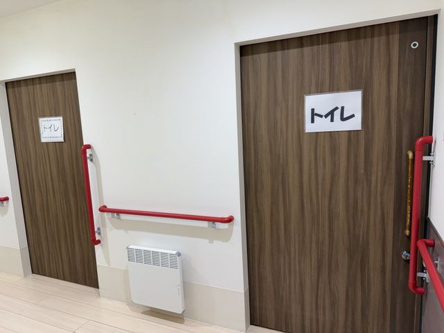 シンプルなトイレ入口 トイレ 利用者の安全を考慮した手すり付きで、安心してご利用いただけます。