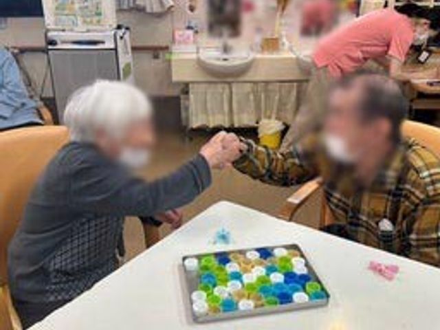 活動中の様子です リビング 和やかな雰囲気の中で、テーブルを囲んで楽しい交流が行われています。暖かなコミュニケーションを体験できます。