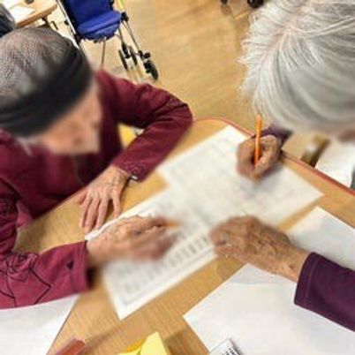 書類作成をする高齢者たちのテーブル