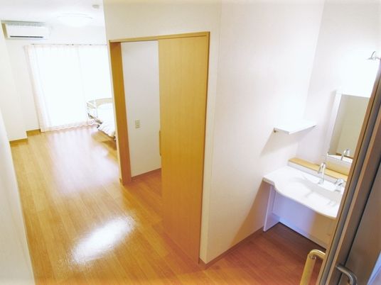 明るい居室のドアと洗面台