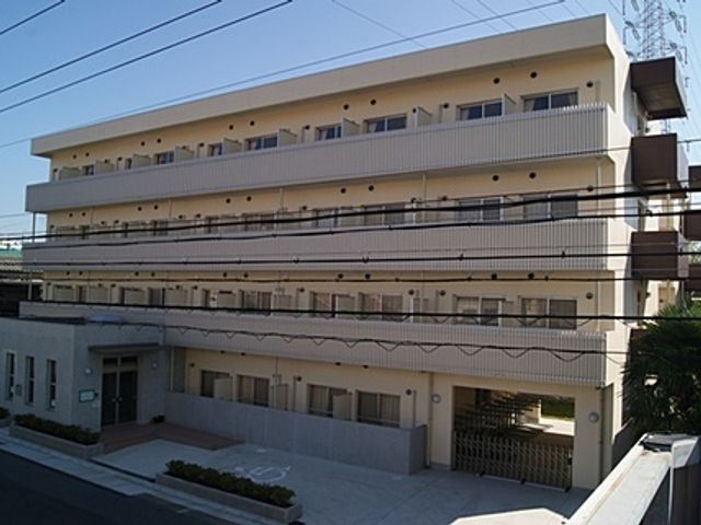 四階建ての建物外観 外観 四階建ての施設は通勤がしやすい場所に位置しています。明るい印象のエントランスもあります。