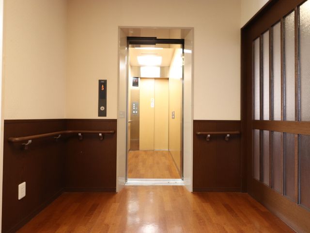 廊下にあるエレベーター エレベーター 手すりが備わった廊下に面したエレベーターがあり、移動の安全と利便性をサポートしています。