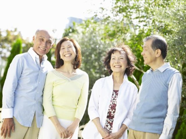 笑顔の高齢者4人組 面会 青空の下、庭園で談笑するご利用者様の笑顔が満開です。心地よい環境でのコミュニケーションを重視しています。
