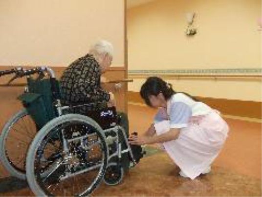 車椅子の足元を調整するスタッフ