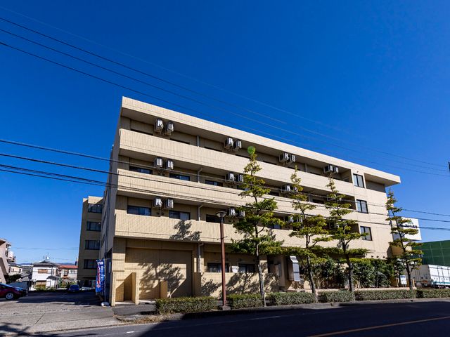 清潔感のある建物外観 外観 青空に映える落ち着いた色合いの建物です。広々とした駐車場が整備されています。
