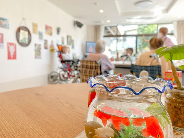 魚の飾りがある室内 リビング 自然光あふれるリビングで、介護を受ける方々がリラックスできる、心地よい空間です。