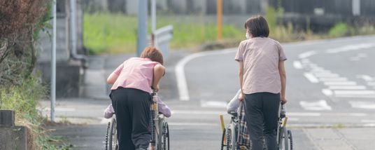 道を進む車椅子利用者とスタッフ
