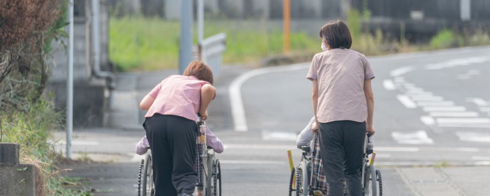 道を進む車椅子利用者とスタッフ