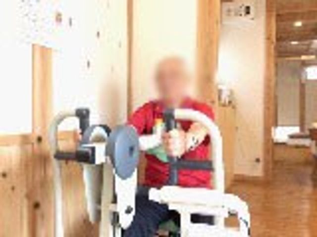 訓練に励む室内 機能訓練室 ゆったりとしたスペースで、機能訓練に専念できる環境が整っています。利用者が真剣に取り組む様子が見受けられます。