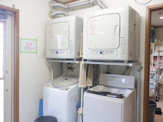 白い洗濯機並ぶ部屋