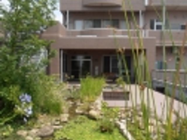風景の前に建物 外観 施設のエントランス前には、美しい池のある庭園があります。自然と触れ合える環境です。