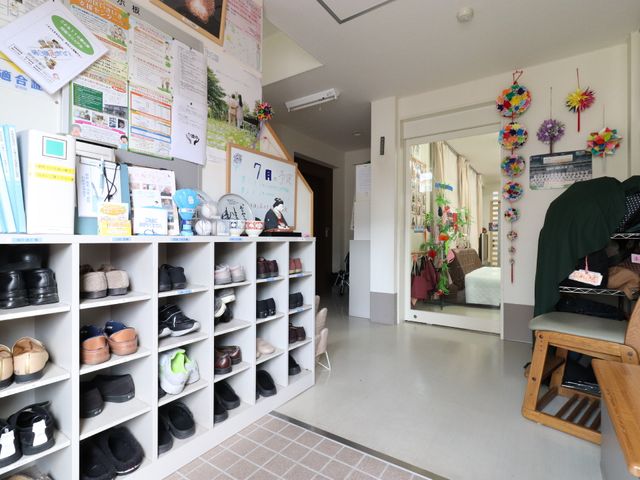 エントランスに靴棚と掲示物 玄関 明るく開放的なエントランスには、色とりどりの装飾が施され、訪れる人を温かく迎えています。