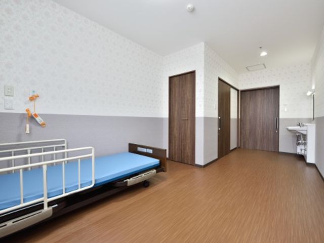 居室の清潔な空間 居室２ 広々とした居室は、清潔感のあふれる造りで、快適な生活が想像できます。ベッドや洗面台も備え付けられ、日々の暮らしに必要な設備が整っています。