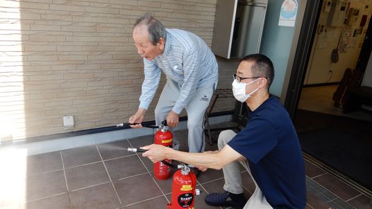 消火訓練を行う利用者とスタッフ