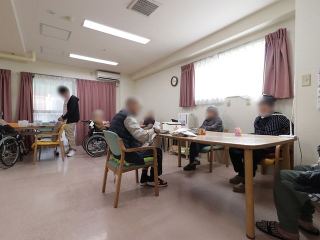 居心地の良い共有スペース 共有スペース 広々としたスペースでゆったりと過ごせる多目的室です。スタッフが優しく対応しており、利用者の方々は穏やかな時間をお過ごしになっています。